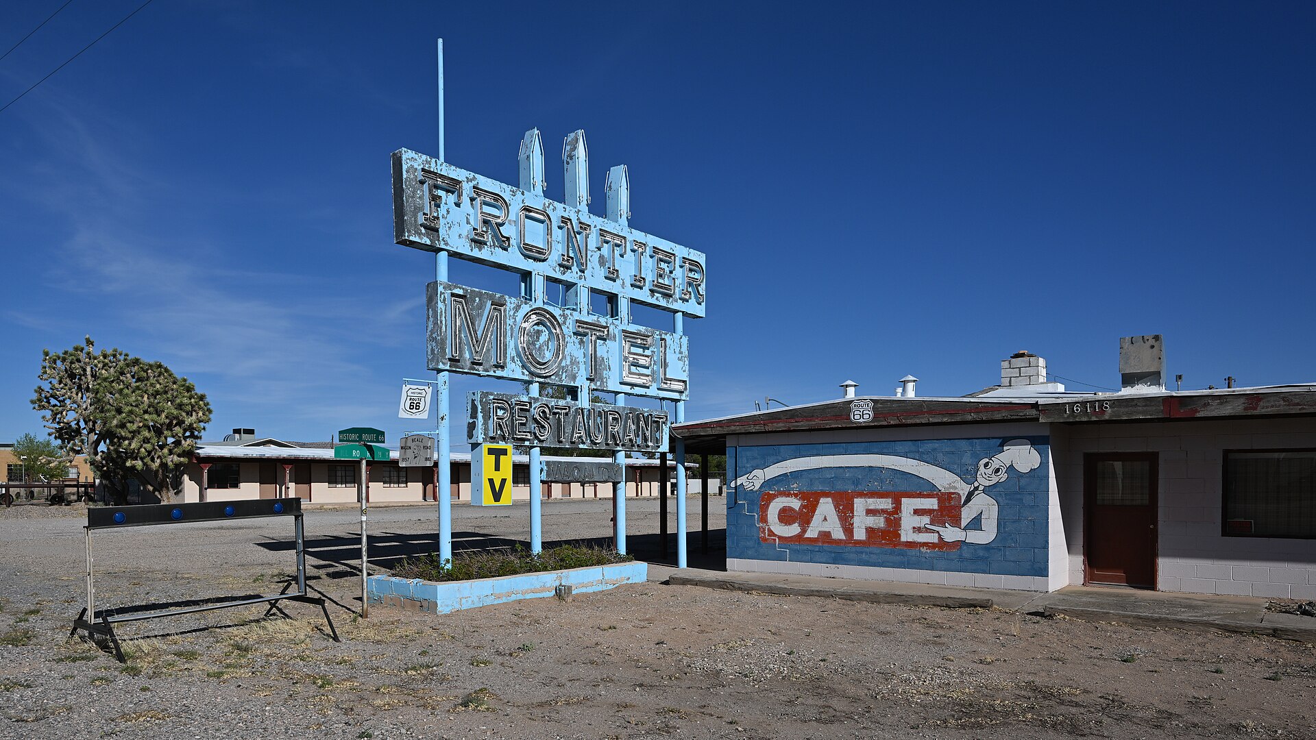 The blue Frontier Motel and Restaurant sign, with an additional sign saying "Cafe" painted on the building. 16118 East Route 66, Truxton, Arizona 86437.