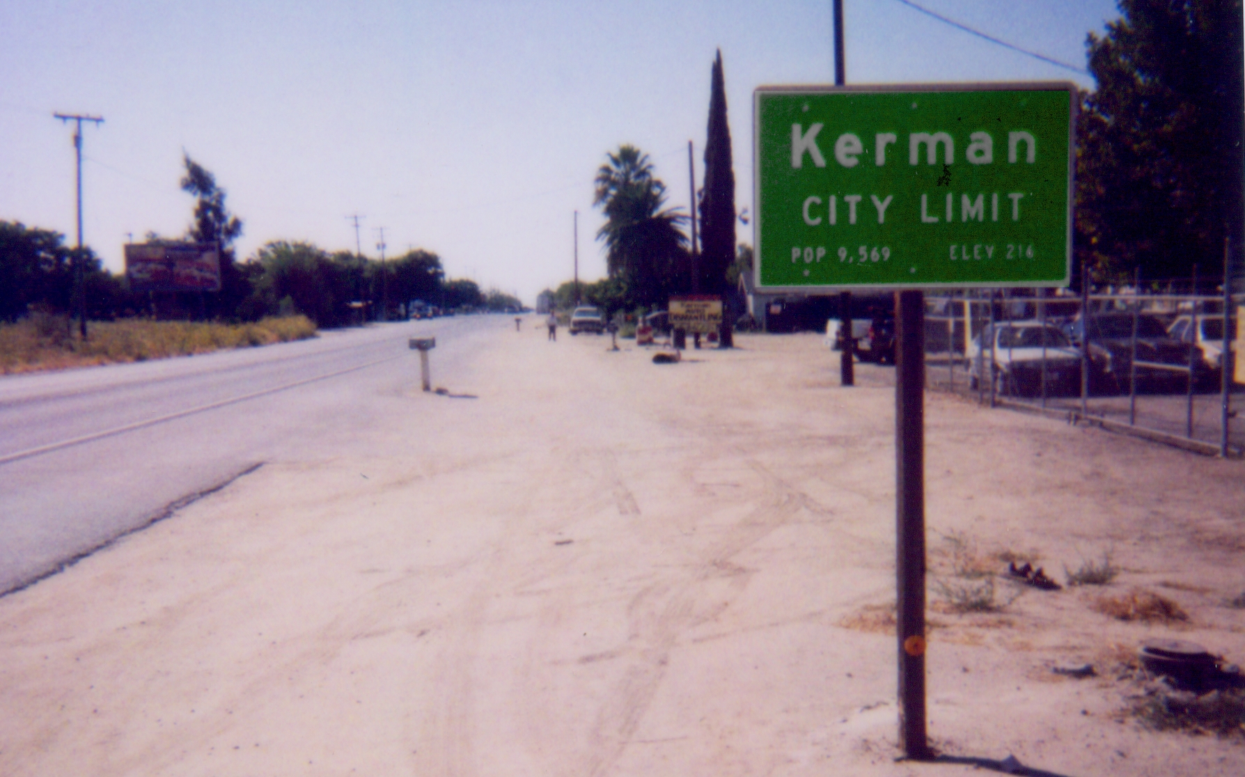 Documentary snapshot of city limit sign along SR180 on the east side of Kerman. — California