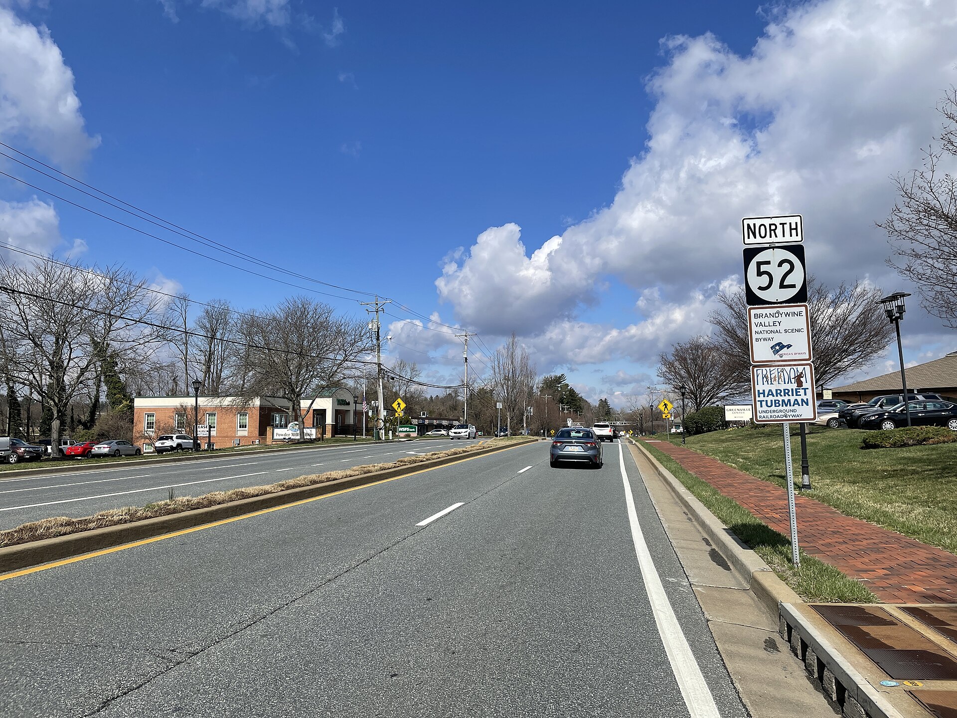 Northbound Delaware Route 52 (Kennett Pike) past the intersection with Buck Road in Greenville, Delaware