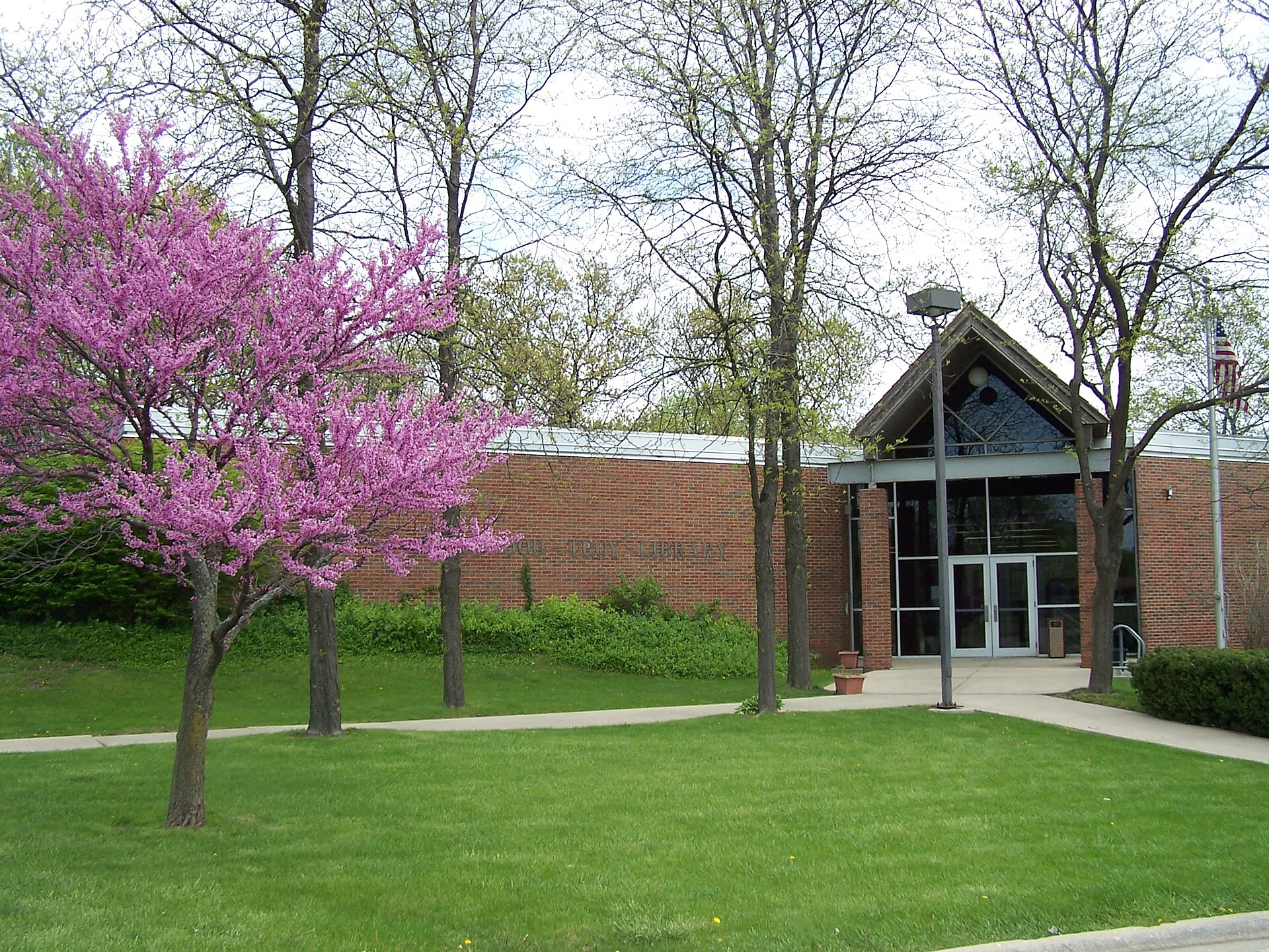 Shorewood-Troy Public Library, Shorewood, Illinois. At the left, some kind of redbud tree in bloom.