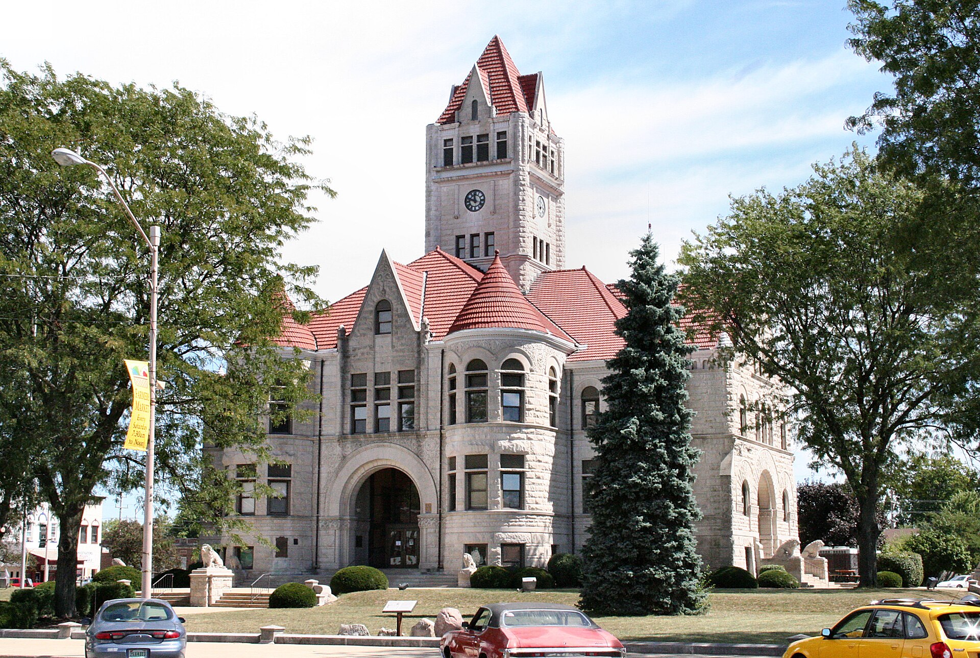 Fulton County courthouse in Rochester, Indiana: West facade to Main Street (left) and South facade to 9th Street (right). Trail of Death Memorial in the foreground