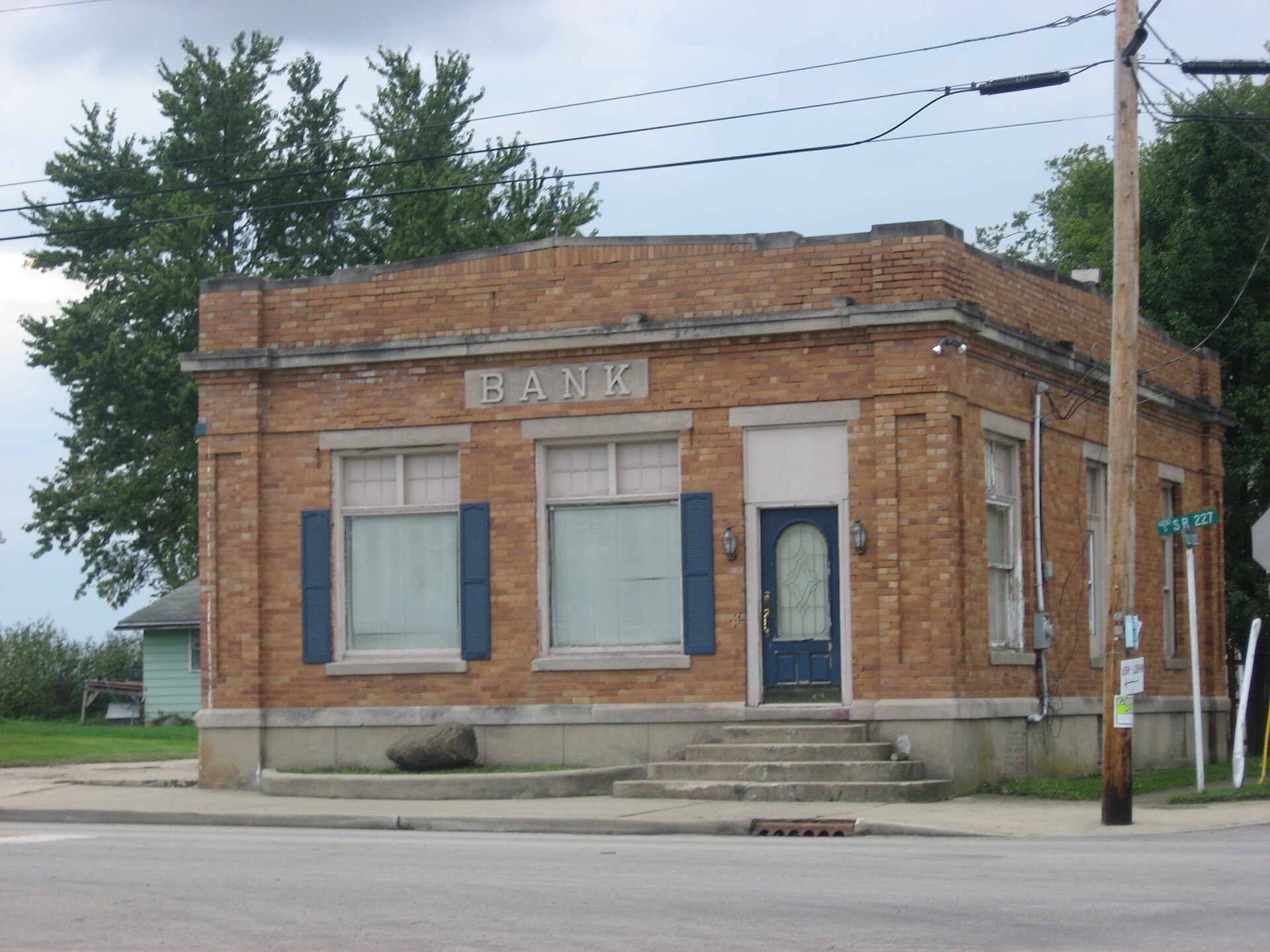 Front and northern side of a former bank on the southwestern corner of the junction of Salem (State Road 227) and Main Streets at the center of Boston, Indiana, United States.