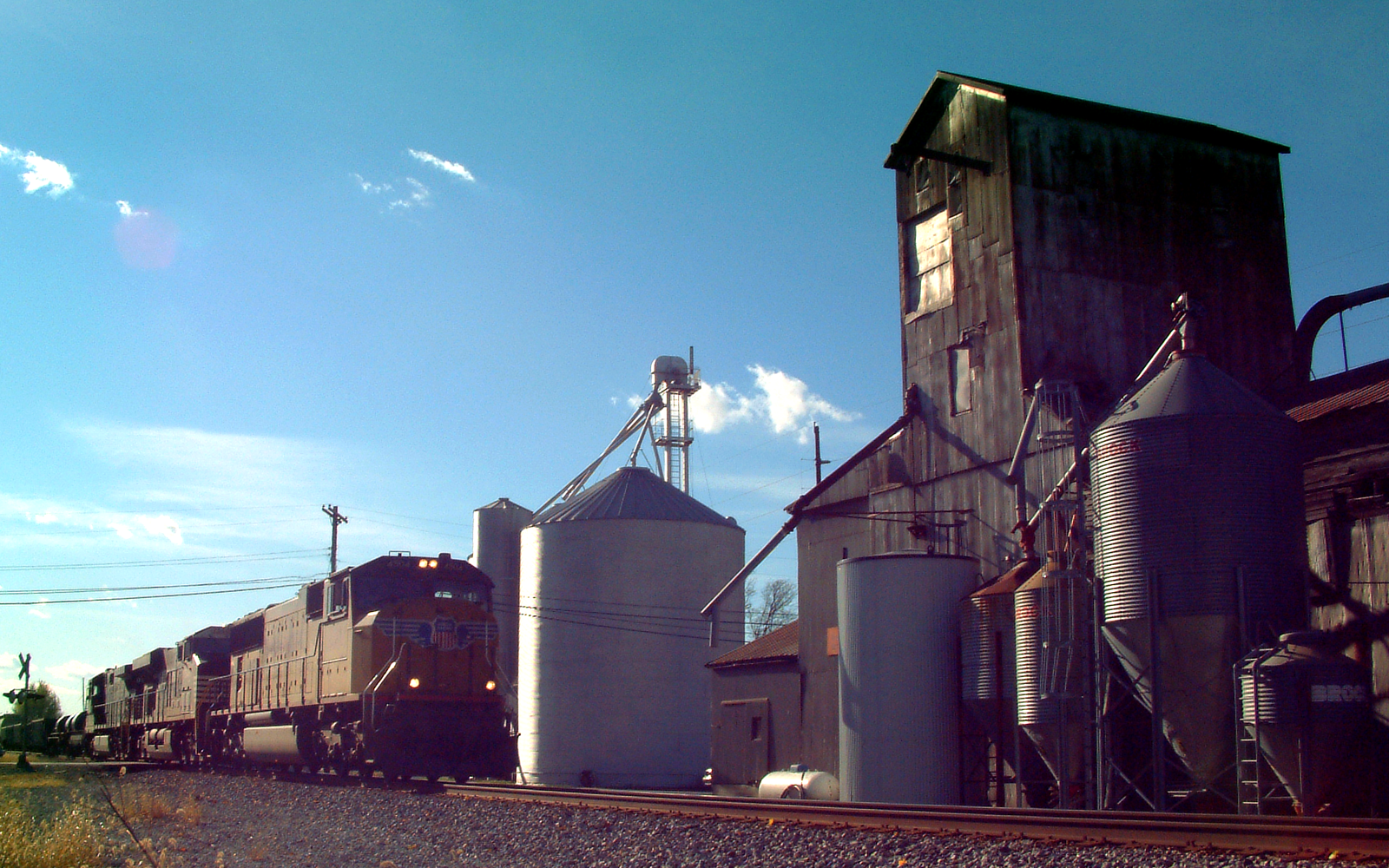 A freight train passing grain elevators in the town of Buck Creek, Indiana. This view looks west from near Miller Street.