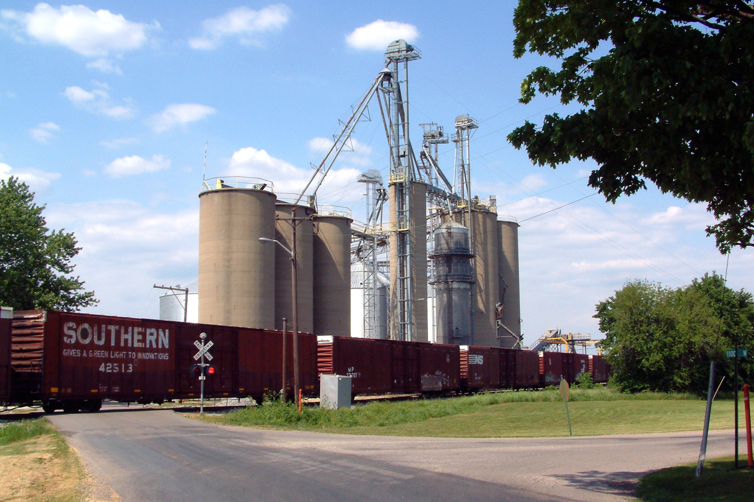 A Norfolk Southern freight train passes the grain elevators in State Line City, Indiana. This photo, taken near the corner of State Line Road and Woodard Street, looks northeast.