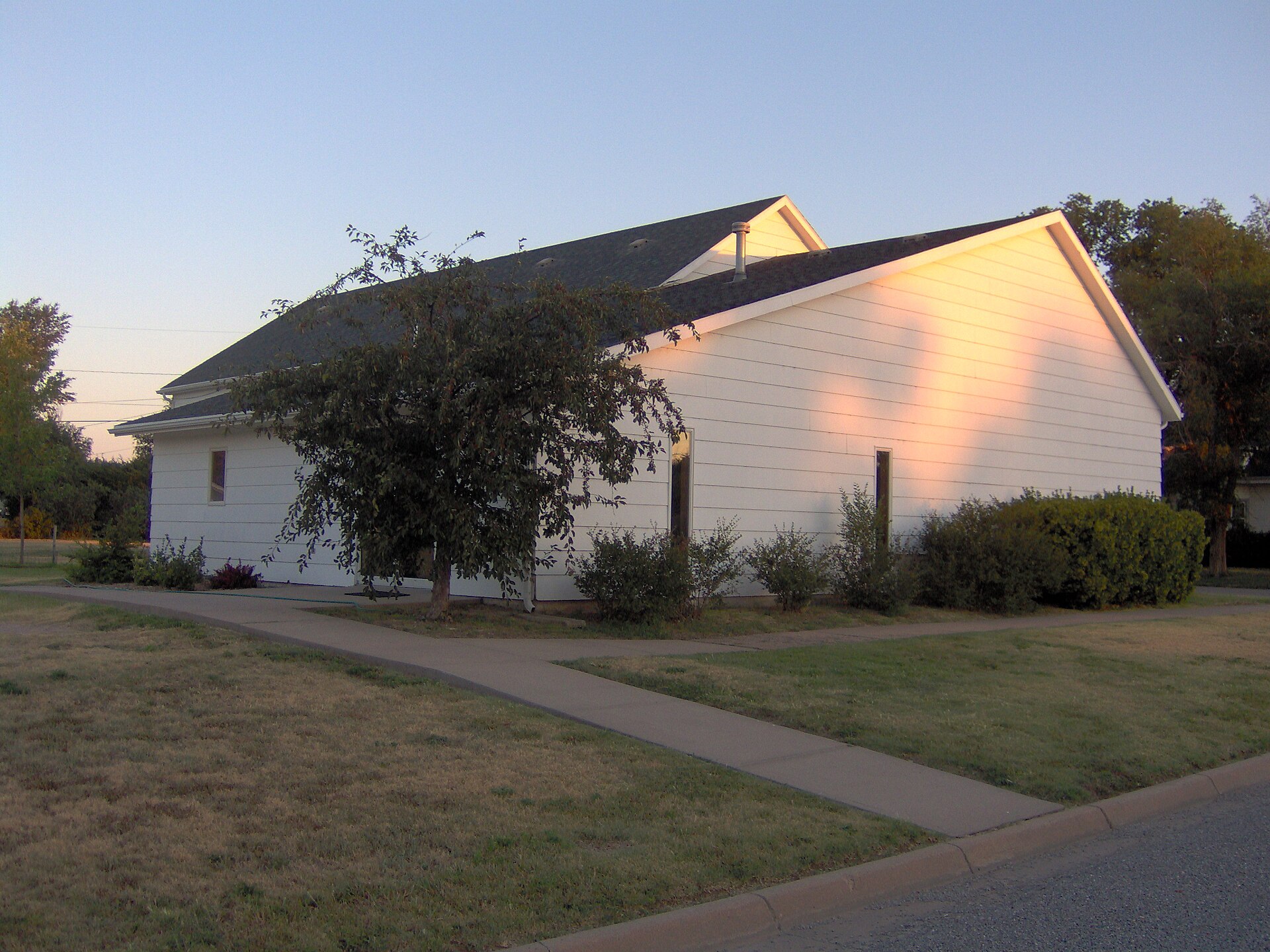 Eastern side and rear of the Minneola Reformed Presbyterian Church, located at 405 Locust Street in Minneola, Kansas, United States.