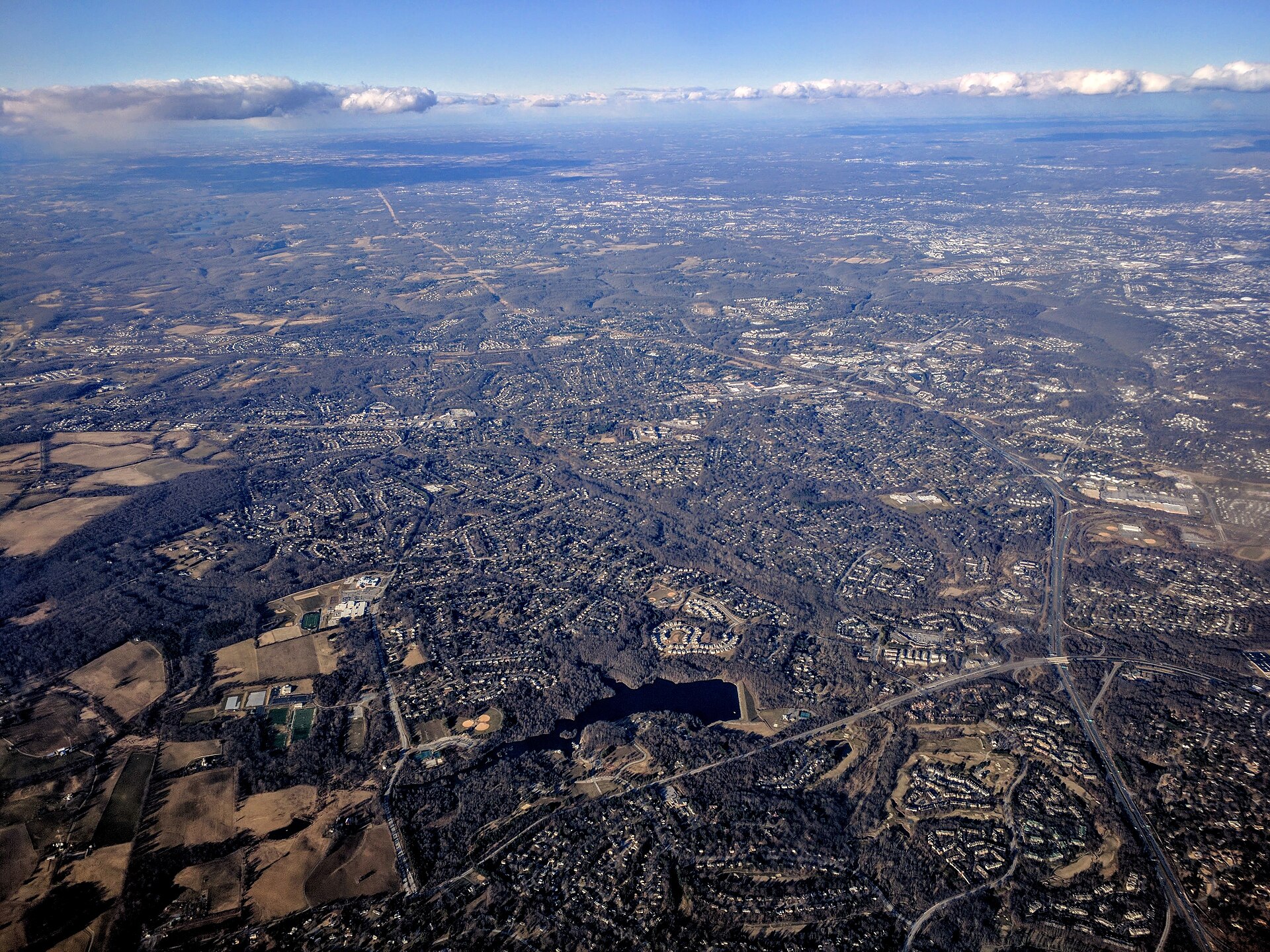 Aerial view with Centennial Lake (Maryland) (lower center) in Centennial Park, in Ellicott City, Maryland, the suburb of Baltimore that fills the center of the photo.