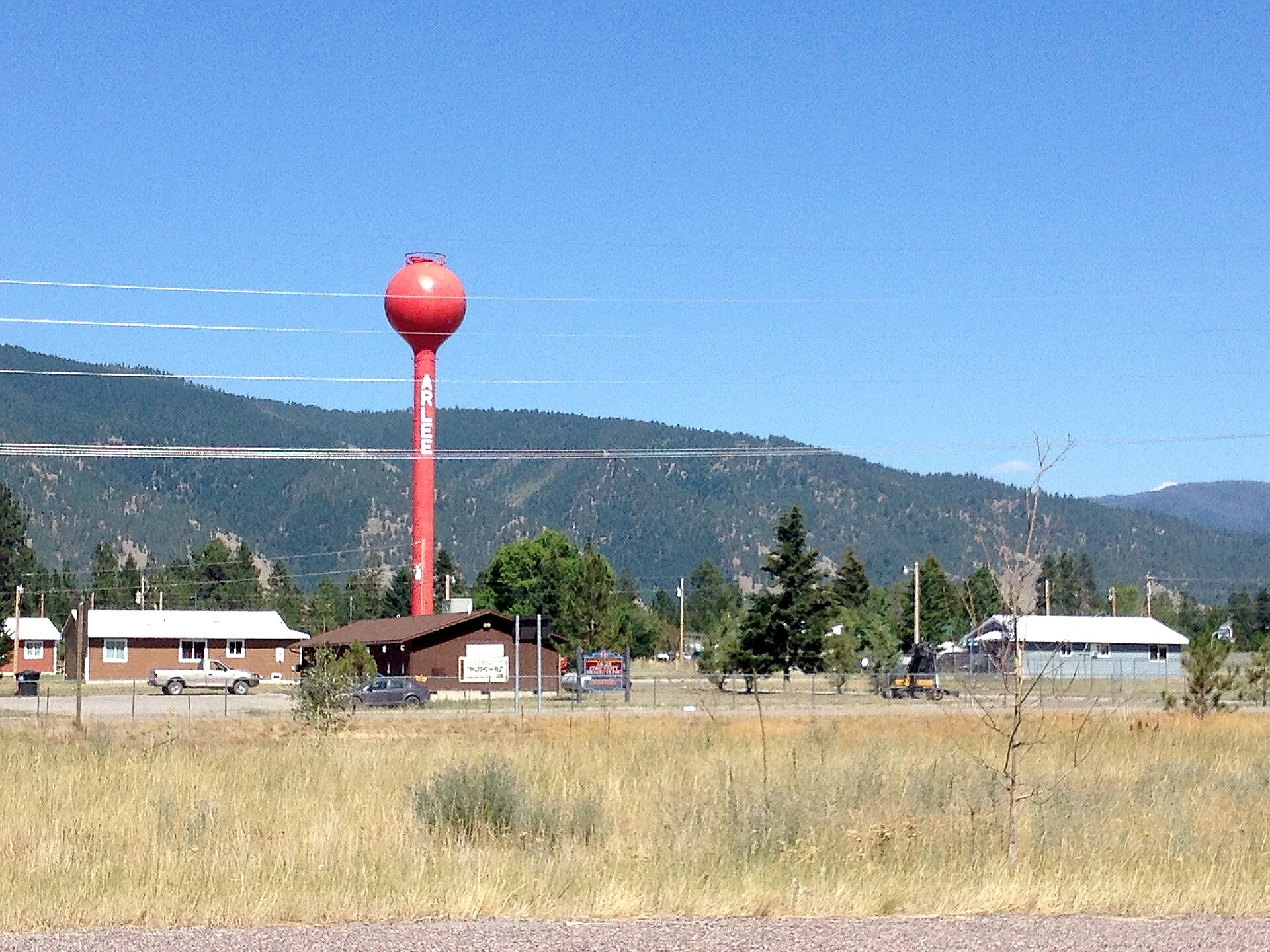Red water tower in Arlee, Montana, with mountains. Photographed July 23, 2013.