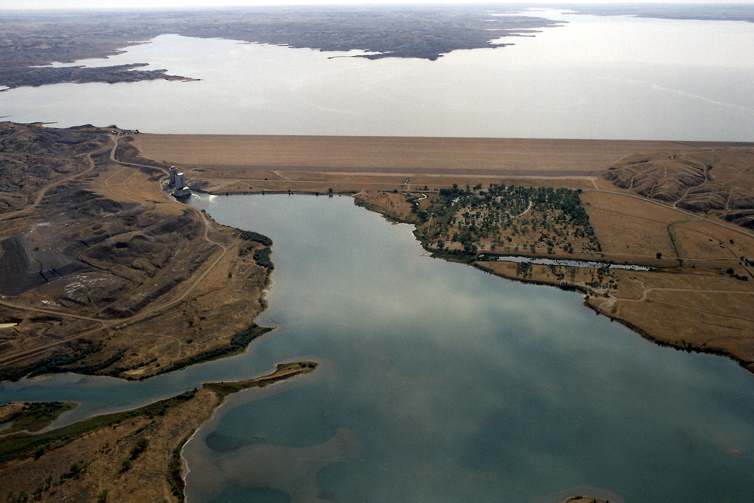 Fort Peck Dam on the Missouri River near Fort Peck, Montana, USA. View is upriver to the southeast.