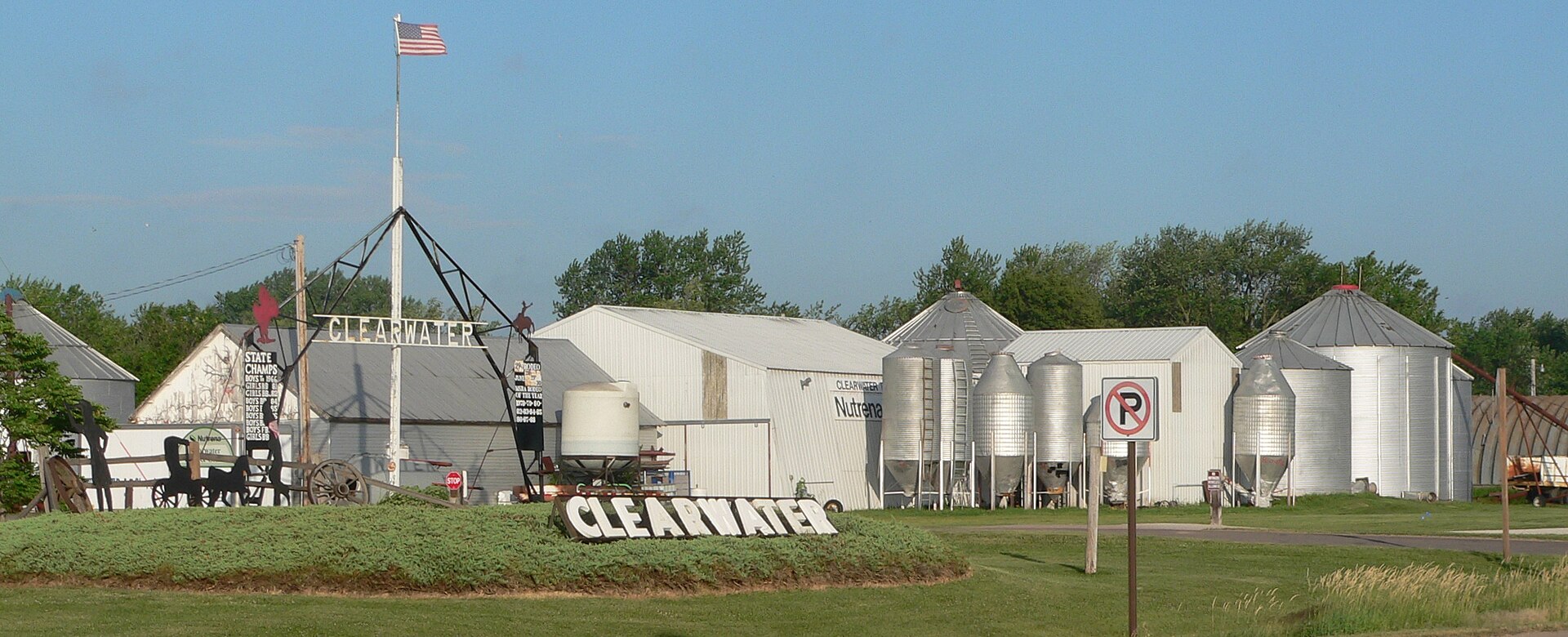Grain bins and welcome signs at north edge of Clearwater, Nebraska, on south side of U.S. Highway 275.