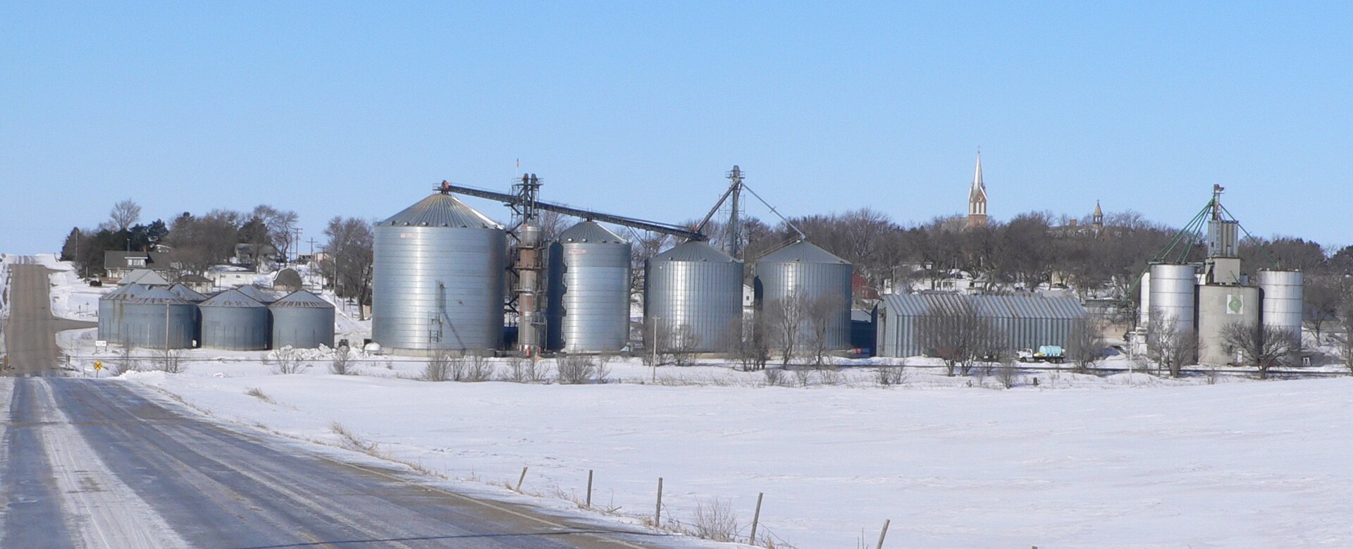Tarnov, Nebraska, seen from the east. In the foreground are grain elevators along the tracks of the Nebraska Central Railroad; atop the hill right of center is the steeple of St. Michael's Catholic Church.
