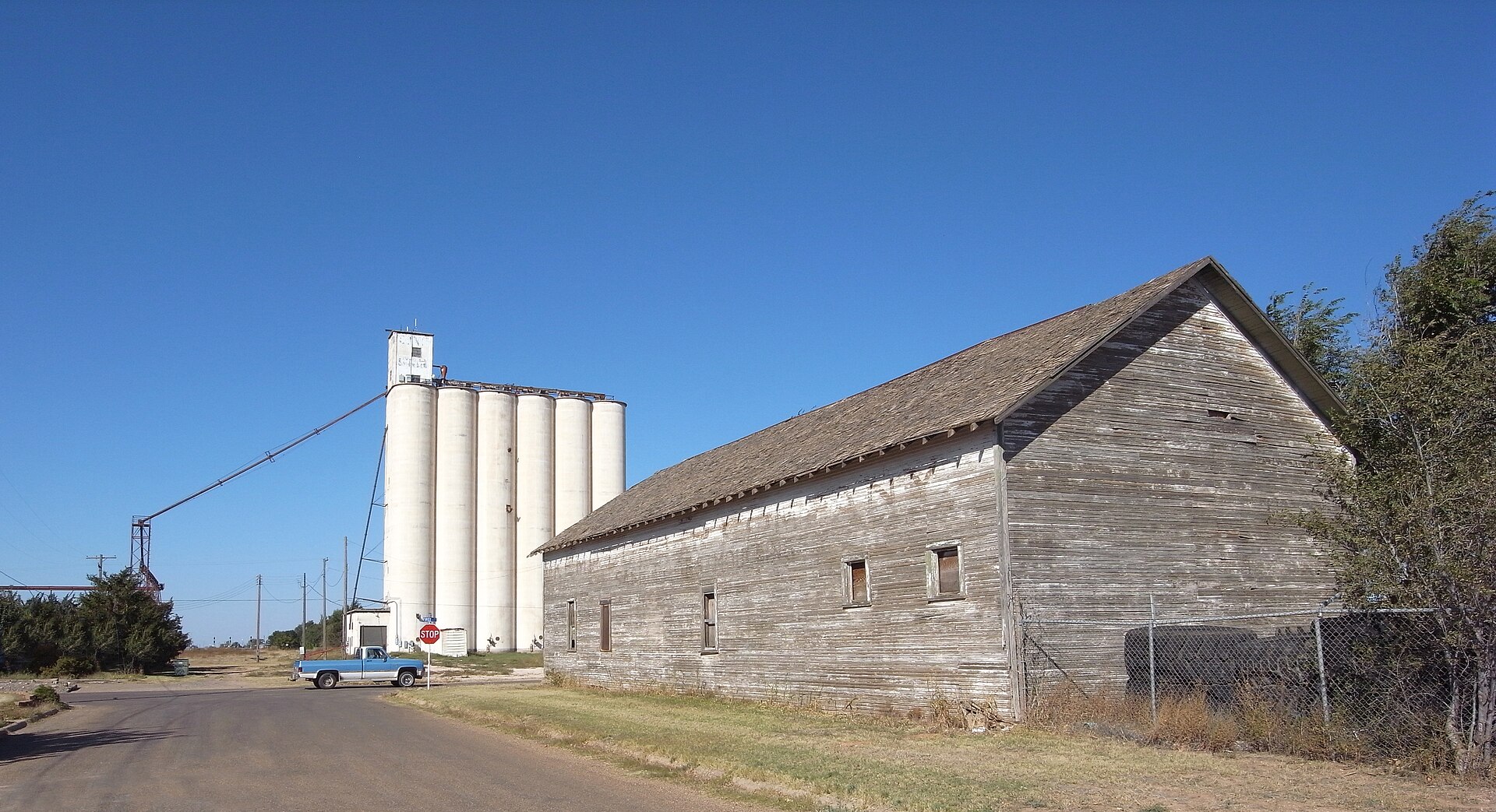 Grain elevator and wooden building at the border of Texas and New Mexico. Elevator is in Texico, New Mexico whereas wooden building is in Farwell, Texas.
