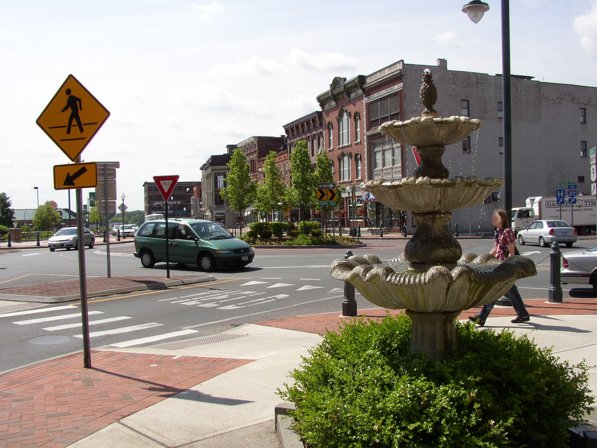 Centennial Circle roundabout in downtown Glens Falls, New York, with sidewalk fountain in foreground. Taken from corner between Ridge & Glen Streets, facing southwest.