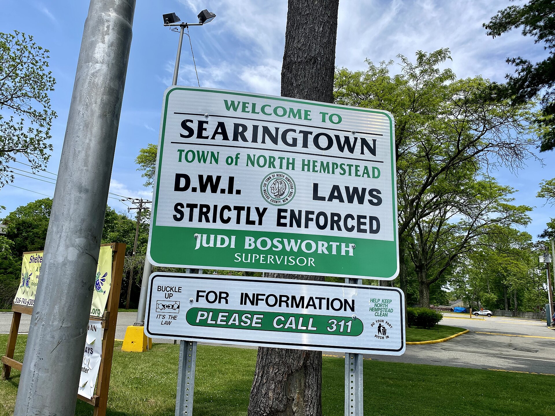A welcome sign to Searingtown, Long Island, New York at the northern end of Herricks Road, at its intersection with Shelter Rock and Searingtown Roads. This photo was taken on May 20, 2021.