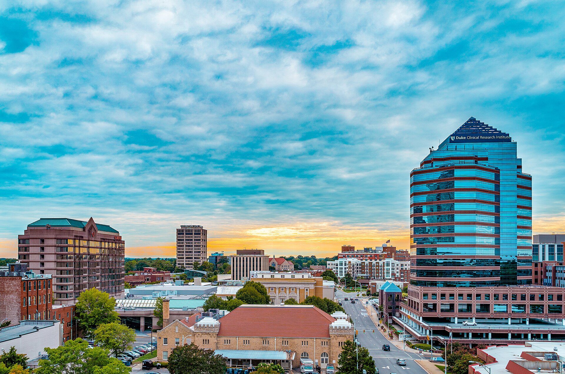 The downtown Durham skyline during an heavily clouded sunset. Durham Centre, the NC Mutual Life building, and the Durham Marriott are visible on the horizon. — North Carolina