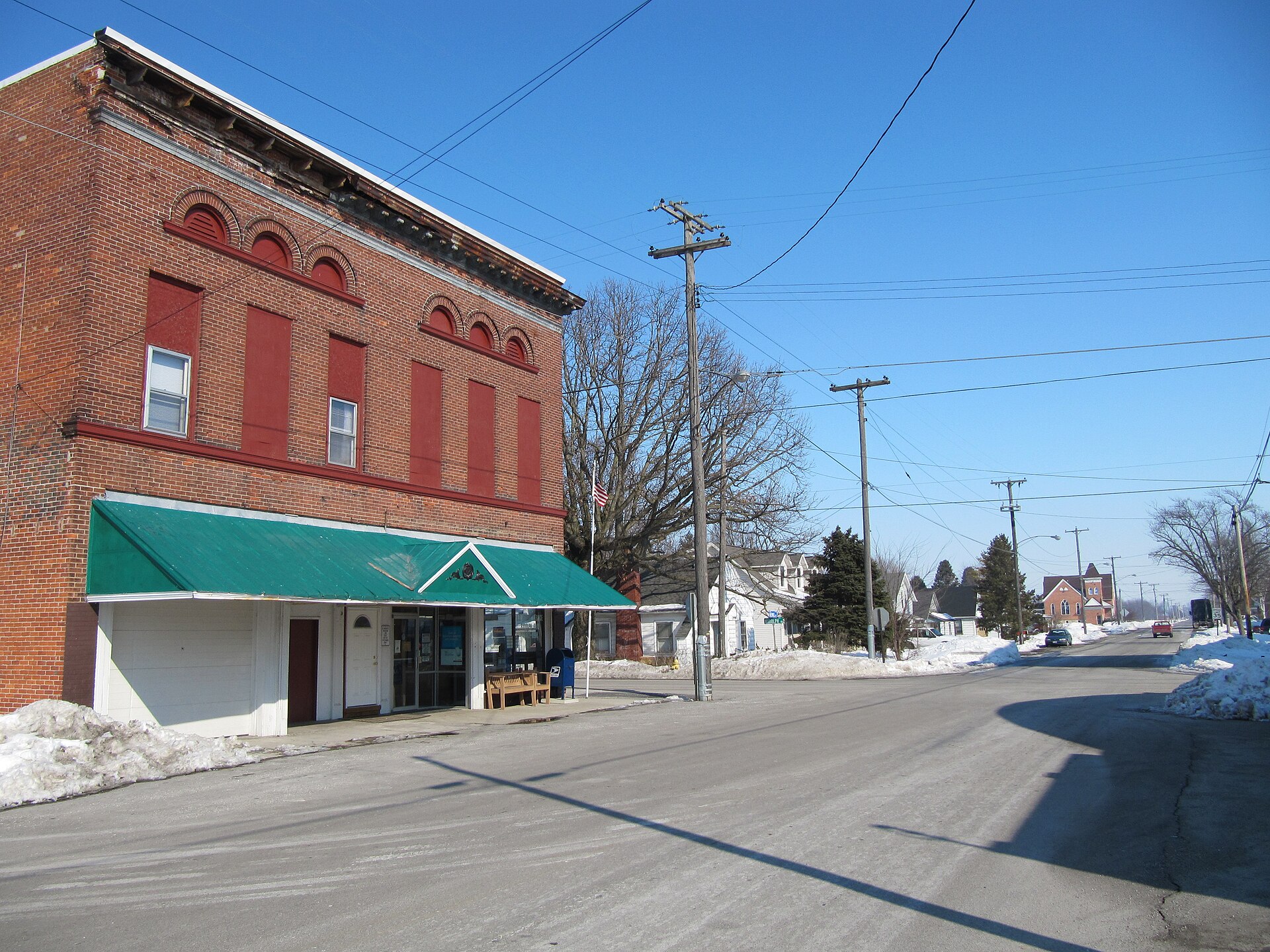 Photograph of the unincorporated community of Rudolph, Ohioen, taken at street level from Main Street, looking East toward the local office of the United States Postal Serviceen and Mermill Road.