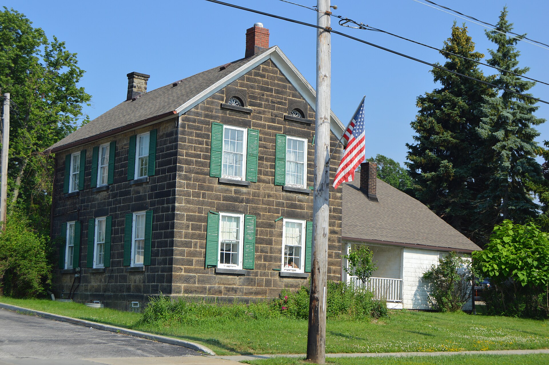 Western side and front of the John Froelich House, located at 7095 Broadview Road (State Route 176) in Seven Hills, Ohio, United States. Built in 1843, it is listed on the National Register of Historic Places.