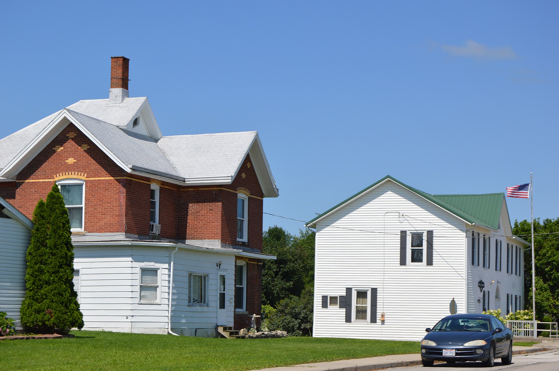 A house and the village hall, located on Main Street northwest of Sycamore Street in West Leipsic, Ohio, United States.