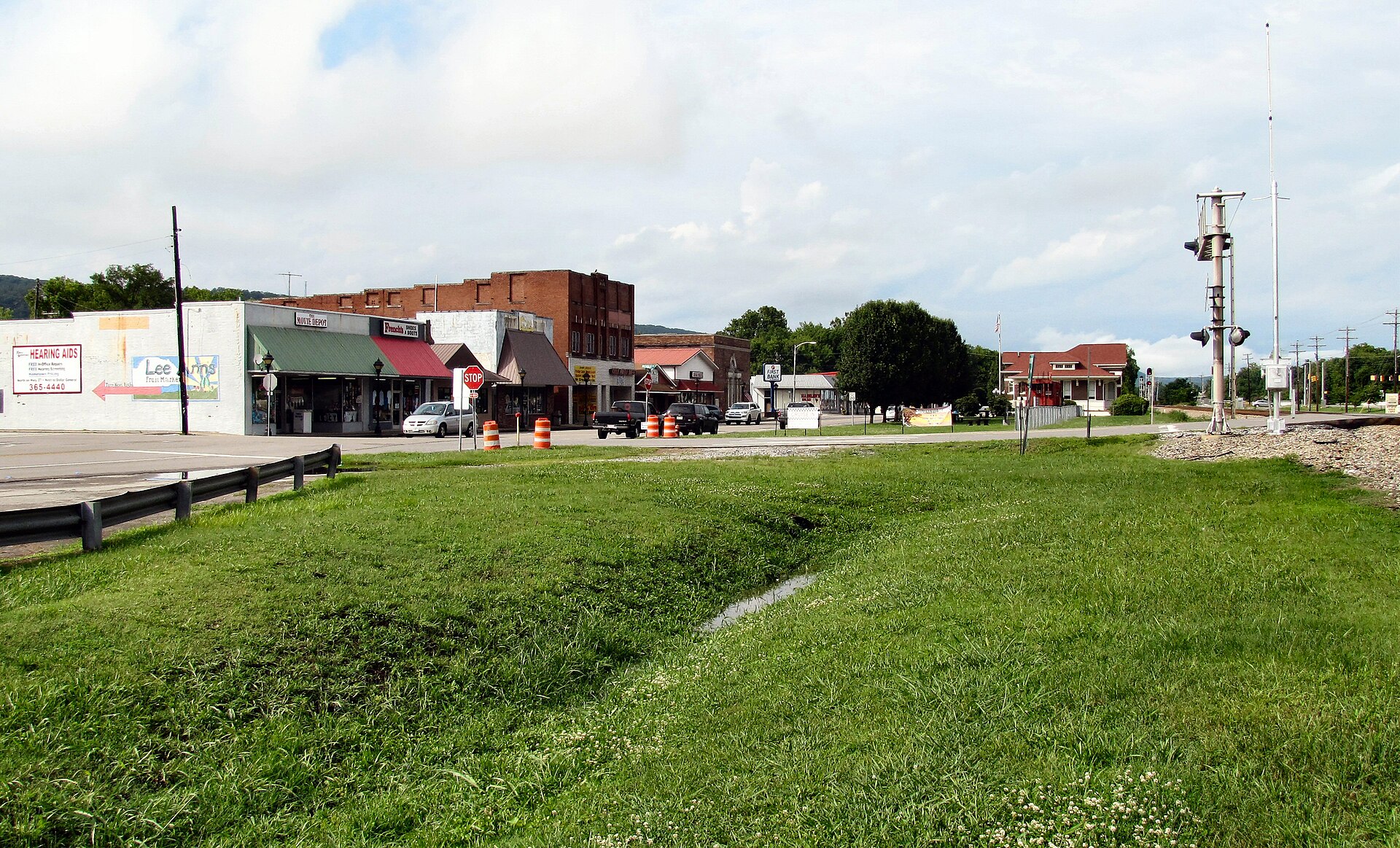 Spring City, Tennessee, United States. Storefronts along Front Street are on the left, and the Norfolk Southern tracks are on the right. The Spring City depot is in the distance on the right.