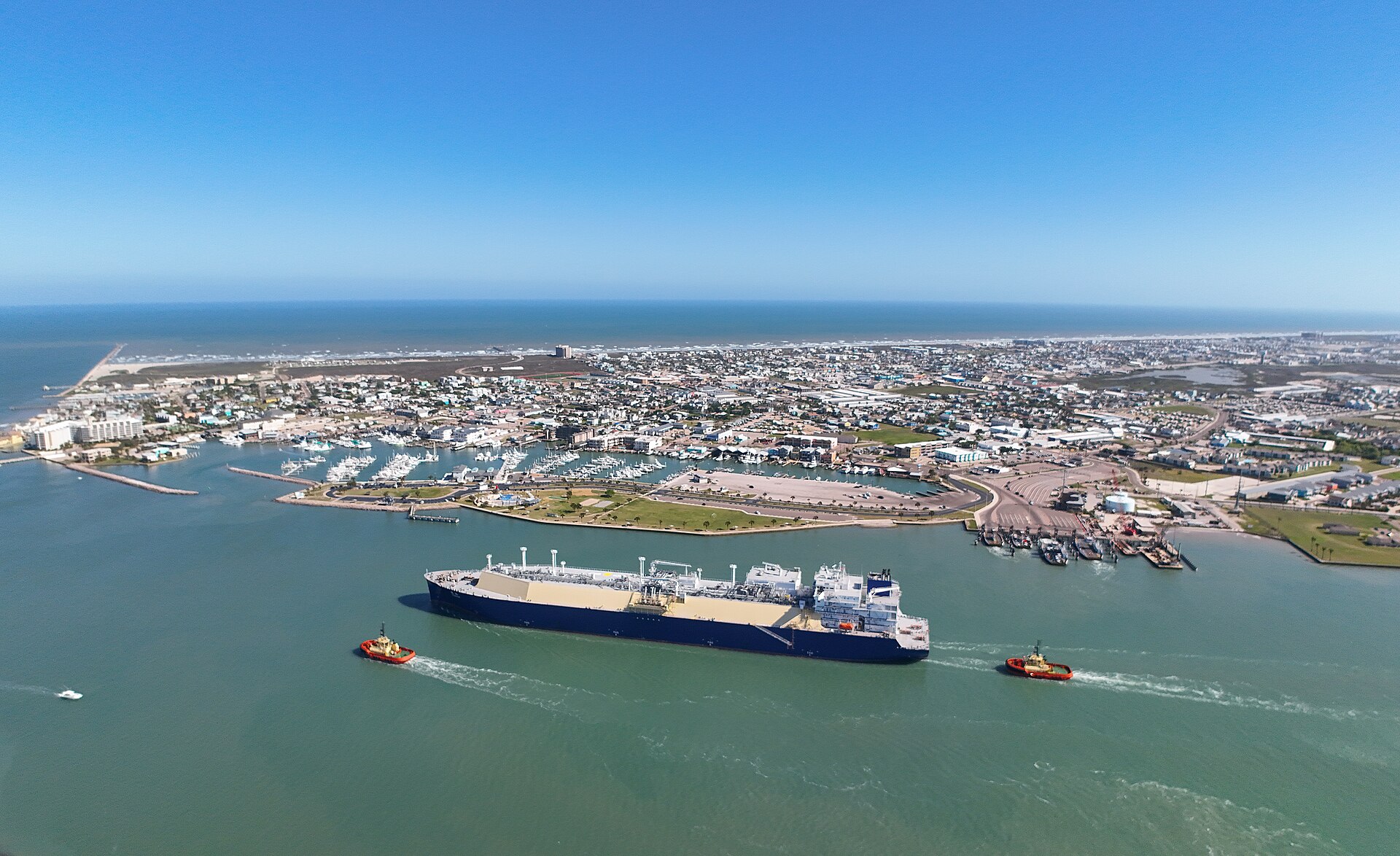 Aerial view of Port Aransas, Texas with an LNG carrier ship passing through
