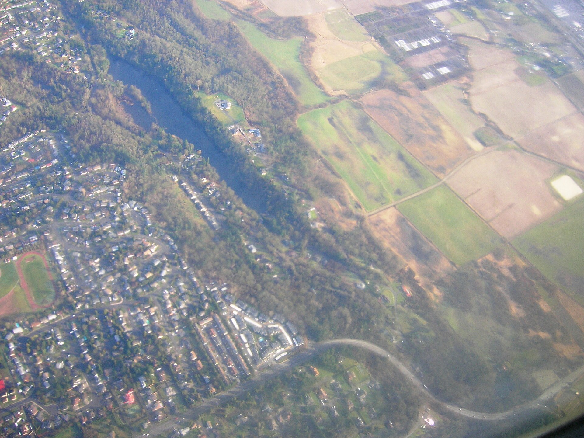 Original caption: "Airborne over Algona, Washington" Specifically appears to be Lake Fenwick, which straddles the border of Kent, Washington.