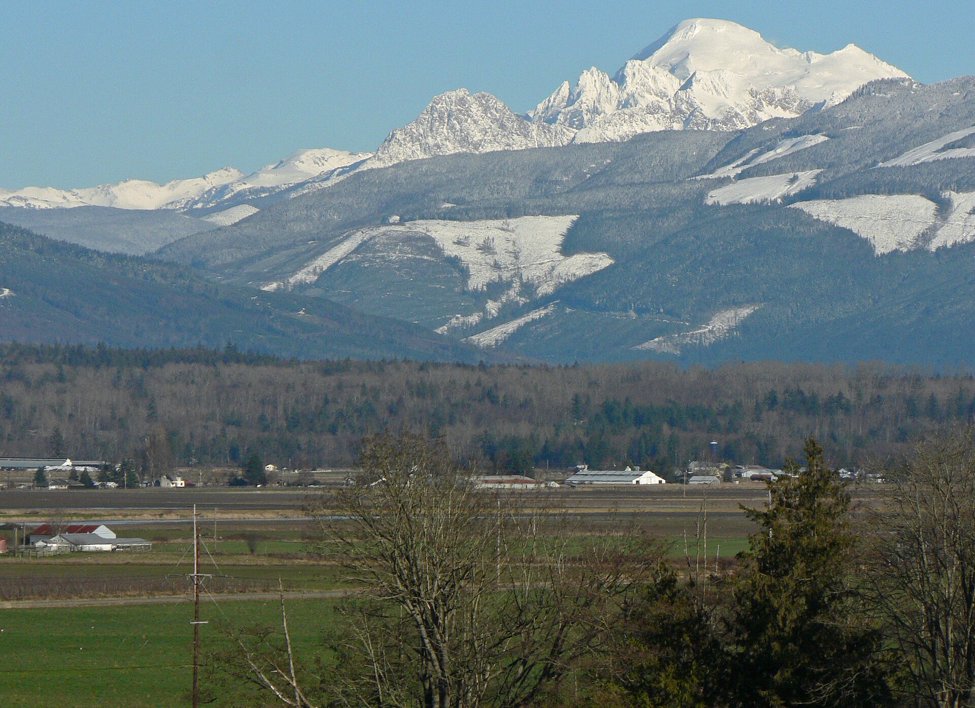 Mount Baker (right skyline, 10,781 feet, 3286 m); Twin Sisters Mountain, North Twin (center skyline, 6640+ feet, 2024+m); Samish River Delta (foreground) — Bay View, Washington